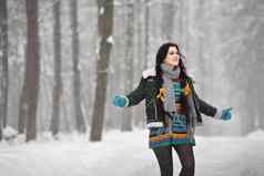美丽的年轻的女人毛衣冬天走公园