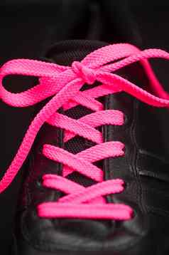 粉红色的用带子束紧运动鞋