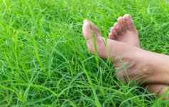 女人只脚绿色草放松假期概念