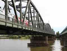 绿色金属铁路桥红色的火车穿越河