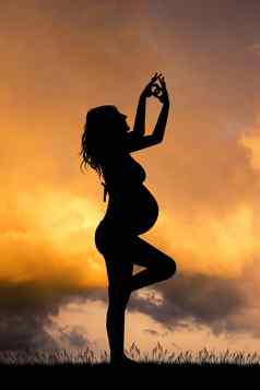 怀孕了女孩瑜伽日落