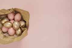 复活节鸡蛋木碗粉红色的黄金复活节鸡蛋粉红色的柔和的复活节概念鸡蛋羽毛古董报纸