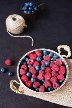 新鲜的树莓蓝莓黑暗图片新鲜的水果浆果铜杯碗黑暗风格股票照片黑色的背景