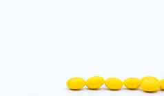 黄色的糖涂层平板电脑药片白色背景复制空间医学治疗便秘制药行业药店背景全球医疗保健概念健康预算政策