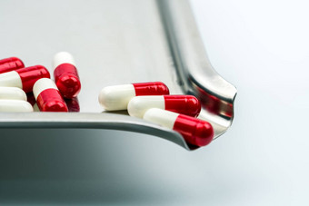 红色的白色抗生素胶囊药片不锈钢钢药物托盘药物电阻抗生素药物合理的健康政策健康保险概念制药行业药店背景