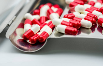 红色的白色抗生素胶囊药片不锈钢钢药物托盘药物电阻抗生素药物合理的健康政策健康保险概念制药行业药店背景