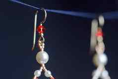 手工制作的珠宝使珠子宏耳环白色珠子耳环石头美丽的饰品耳环红色的珠子饰品黑色的背景