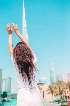 快乐女人走迪拜摩天大楼背景视图