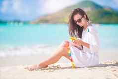年轻的女人智能手机热带海滩假期美丽的女孩海滩手机加勒比岛
