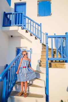 可爱的女孩蓝色的衣服街典型的希腊传统的村米克诺斯岛希腊