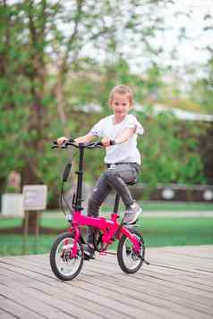 可爱的女孩骑自行车美丽的夏天一天在户外