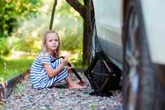 可爱的女孩改变车轮在户外美丽的夏天一天