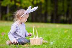 可爱的女孩穿兔子耳朵玩复活节鸡蛋春天一天在户外