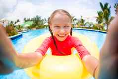 女孩使自拍充气橡胶环有趣的游泳池