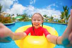女孩使自拍充气橡胶环有趣的游泳池