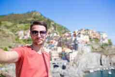 年轻的旅游太阳镜采取自拍风景优美的视图manarola五渔村利古里亚意大利