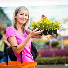 年轻的女人购买花花园中心