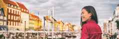 快乐亚洲女人走哥本哈根城市街丹麦春天旅行旅游参观新端口著名的吸引力水运河横幅