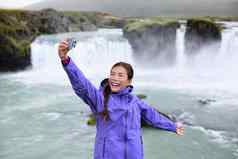 冰岛旅游采取自拍照片聪明的电话戈达福斯瀑布
