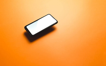 简约模拟平图像设计浮动移动电话复制空间白色小石子写平橙色背景