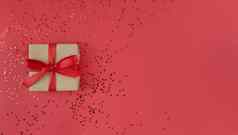 礼物盒子包装工艺纸红色的丝带弓五彩纸屑红色的背景单色节日平躺复制空间