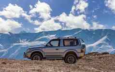 风景优美的视图越野车辆停山白色雪山脊美丽的蓝色的天空背景略焦点阿尔泰山西伯利亚俄罗斯