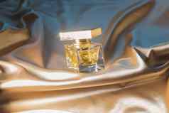 香水瓶黄金折叠丝绸织物背景