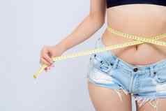 亚洲女人饮食苗条的测量腰重量隔离