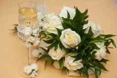 婚礼花束白色玫瑰装饰珍珠柔和的桃子颜色背景香槟玻璃装饰美丽的花边白色玫瑰花珍珠珠子装饰婚礼装饰新鲜的花工作花店装饰