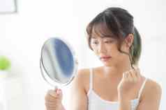 美丽的年轻的亚洲女人镜子痤疮问题