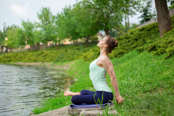 年轻的体育女孩实践<strong>瑜伽</strong>绿色草坪上河<strong>瑜伽</strong>阿三的姿势冥想团结自然