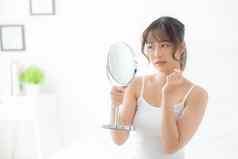 美丽的年轻的亚洲女人镜子痤疮问题