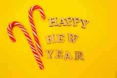 庆祝快乐一年木信一年的帽黄色的背景红色的糖果节日装饰明信片概念前视图平复制空间