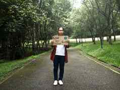 女志愿者持有自然保护标志站自然森林概念世界环境一天