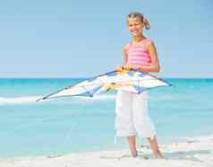 可爱的女孩海滩玩色彩斑斓的风筝