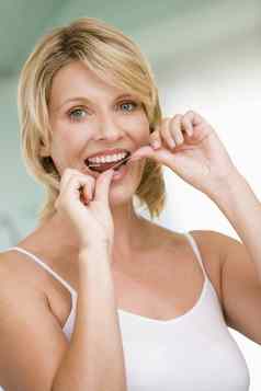 女人用牙线清洁牙齿牙齿