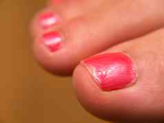 特写镜头粉红色的指甲油漆脚修脚