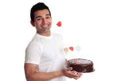 男人。持有美味的巧克力蛋糕装饰爱心