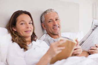 快乐女人阅读书丈夫阅读新闻
