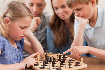 关闭孩子们玩国际象棋前面父母