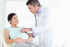 医生检查女人的肚子听诊器