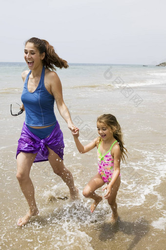 妈妈。女儿运行水海滩