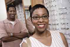 肖像快乐非洲美国女人穿眼镜男人。站背景