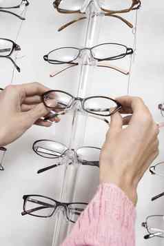 特写镜头女人的手选择眼镜架