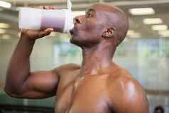 运动男人。喝蛋白质健身房