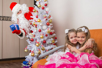 女孩拥抱沙发上圣诞老人老人偷窥树