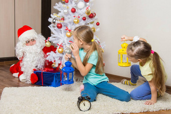 女孩手电筒圣诞老人老人小心翼翼地把礼物圣诞节树