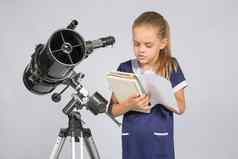 女学生阅读教科书站天文学家望远镜