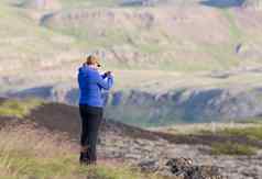 拍摄年轻的女人徒步旅行冰岛