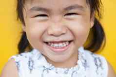 关闭脸亚洲孩子露出牙齿的微笑面部脸宽松外衣
